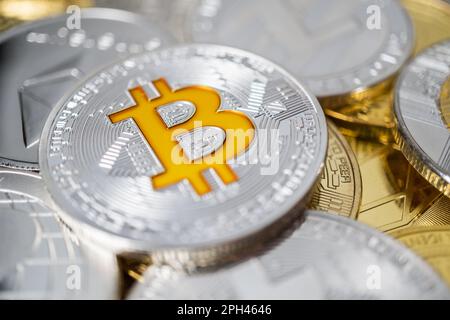 Bitcoin physical coin on the stack of other different cryptocurrencies. Close-up photo of bitcoin with shallow depth of field Stock Photo