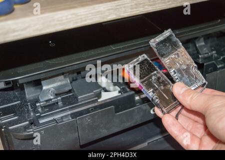 Replacing the ink in the printer, the human hand takes out the cartridge Stock Photo