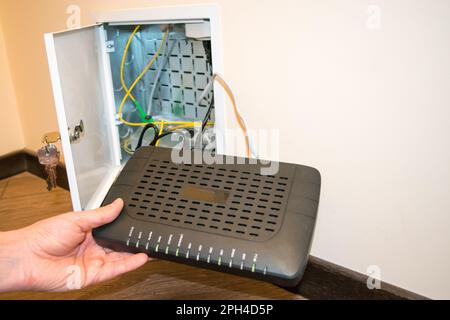 Open box to router, human hand human hand is holding black router Stock Photo
