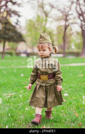 Sad baby girl in Soviet military uniform  Stock Photo