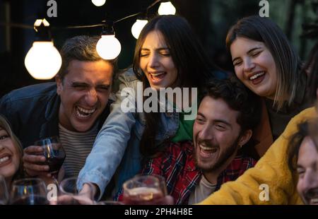 A group of friends of different ages raise their glasses in celebration, enjoying good company and delicious drinks. A family spending time together a Stock Photo