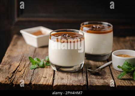 Vanilla panna cotta desert with caramel sause and chocolate in glasses Stock Photo