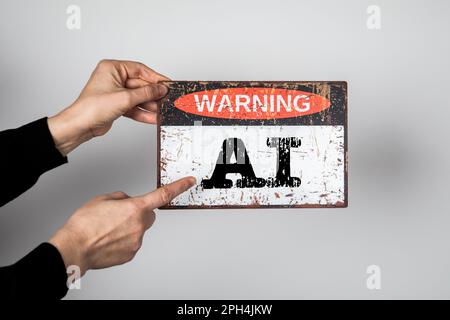 AI. Artificial Intelligence. Warning sign with text in the hands of a woman. Stock Photo