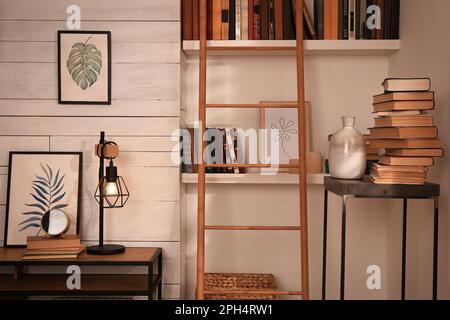 Home library interior with modern furniture and collection of different books on shelves Stock Photo