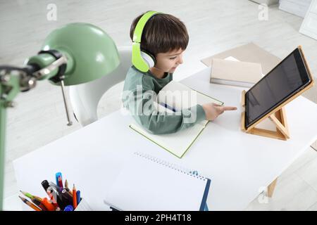 Cute little boy with modern tablet studying online at home. E-learning Stock Photo