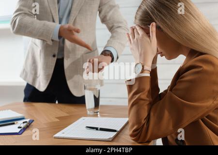 Businessman pointing on wrist watch while scolding employee for being late in office Stock Photo