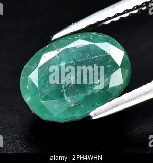 Natural gemstone green emerald on gray background Stock Photo