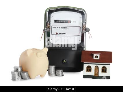 Electricity meter, house model, piggy bank and stacked coins on white background Stock Photo