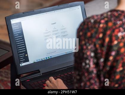 Lisbon, Portugal - March 26, 2023: Illustrative editorial of a woman on laptop using ChatGPT, an artificial intelligence chatbot developed by OpenAI Stock Photo