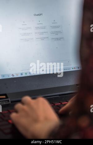 Lisbon, Portugal - March 26, 2023: Illustrative editorial of a woman on laptop using ChatGPT, an artificial intelligence chatbot developed by OpenAI Stock Photo