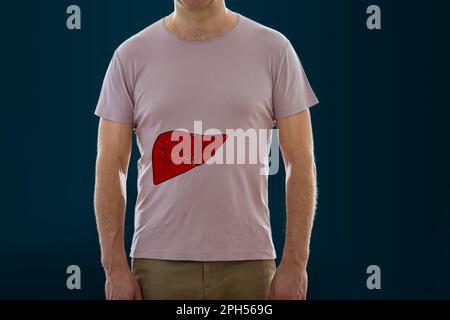 The man standing on a dark background with picture of a liver. Anatomy of healthy human internal organ. Medical concept. Stock Photo