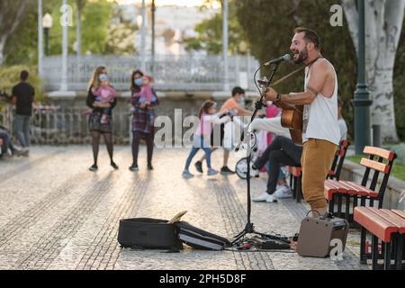 Street musician playing guitar and singing songs in Tavira town, Portugal Stock Photo