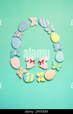 Easter banner on a mint background. Homemade gingerbread cookies. Easter eggs and cookies in the shape of a rabbit and a butterfly. Easter concept. Stock Photo
