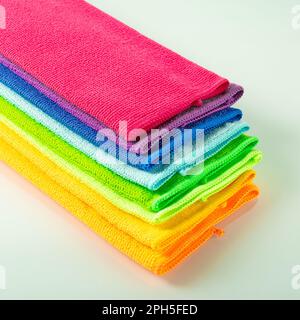 Stack of kitchen microfiber towels in bright colors on a light mirror background Stock Photo