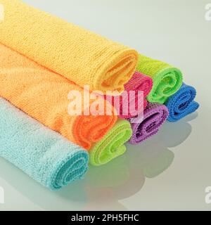 Stack of kitchen microfiber towels in bright colors on a light mirror background Stock Photo