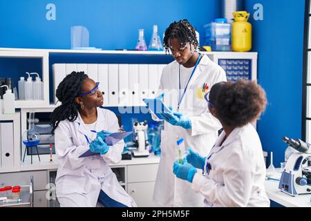 African american friends scientists using touchpad working at laboratory Stock Photo