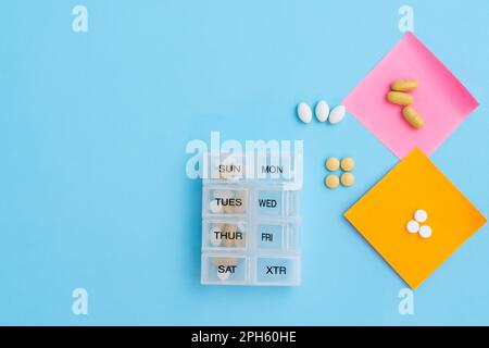 Pills laid out on a table on multi-colored stickers for remembering the order of taking Stock Photo