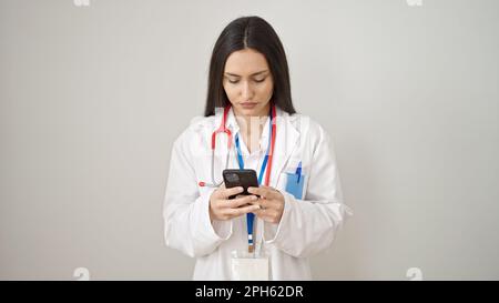 Young beautiful hispanic woman doctor using smartphone over isolated white background Stock Photo