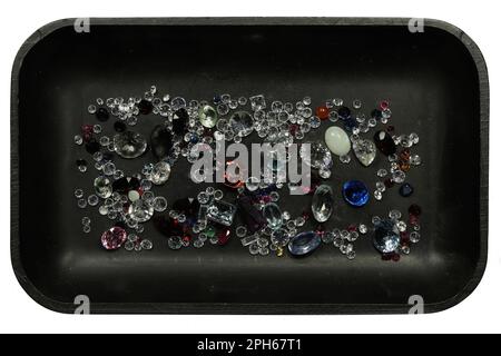 various gemstones in black tray isolated on white background Stock Photo