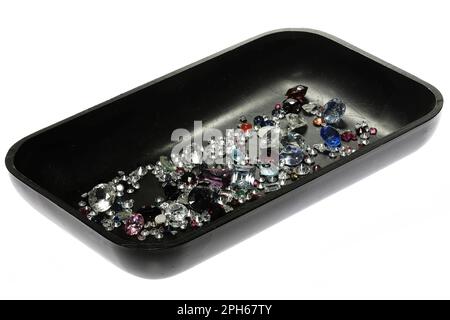 various gemstones in black tray isolated on white background Stock Photo