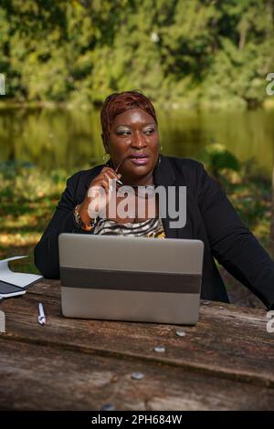 Businesswoman thinking with reading glasses by her face Stock Photo