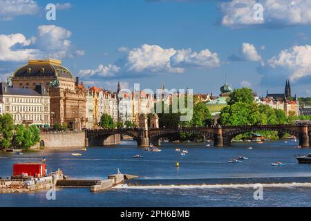 Prague beautiful rivefront on River Vltava with the National Theatre, the Legion Bridge, the Slovansky Island and paddle boats Stock Photo