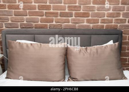 Bed in loft style room with brick wall Stock Photo