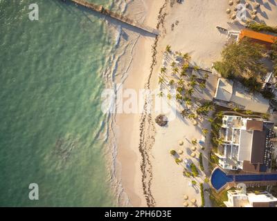 Tropical beach. View from above. Wooden pier in the sea. Hotels, swimming pools, palm trees. Beautiful nature, romance, swimming, sunbathing. Stock Photo
