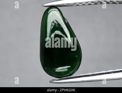 Natural gem green jade on gray background Stock Photo