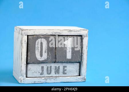 Calendar for June 01 made wooden cubes standing blue background. With empty space for text Stock Photo