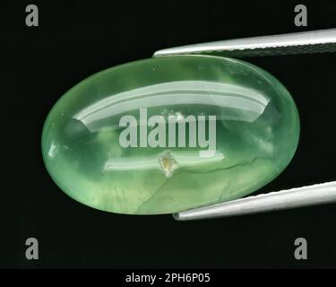 Natural gem green prehnite on gray background Stock Photo