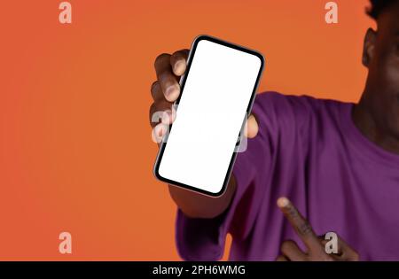 Black man holding cell phone with blank screen, mockup Stock Photo