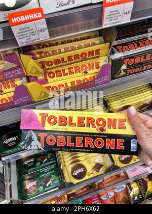 25.03.2023 Ukraine, Kharkov Chocolate Toblerone in hand. Delicious chocolate on store shelves.  Stock Photo
