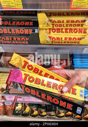 25.03.2023 Ukraine, Kharkov Chocolate Toblerone in hand. Delicious chocolate on store shelves.  Stock Photo