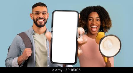 Happy Multiethnic Couple Making Announcement With Megaphone And Showing Blank Smartphone Stock Photo
