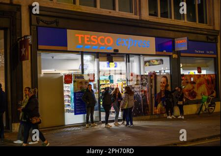 LONDON - November 12, 2022: The entrance to Tesco in London is a hotspot for young people to gather, chat, and socialize while shopping for snacks and Stock Photo