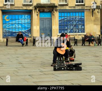 Busker playing guitar, Abby churchyard, Bath.. Taken March 2023. cym Stock Photo
