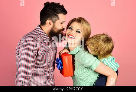 Fathers day celebration. Cute little boy with mother congratulating father. Gift box for birthday. Happy family celebrating holiday together. Cute son Stock Photo