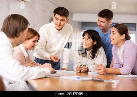 Group of students studying for difficult test in studygroup together Stock Photo