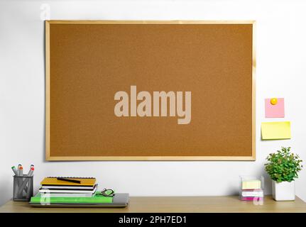 Empty cork board with wood frame over work desk. Place for notes and reminders. Stock Photo