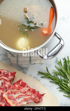 https://l450v.alamy.com/450v/2ph7t7j/delicious-homemade-bone-broth-and-ingredients-on-white-marble-table-flat-lay-2ph7t7j.jpg