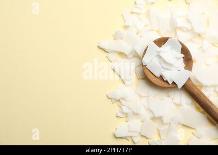 Wooden spoon on heap of soy wax flakes, top view. Homemade candle material  Stock Photo