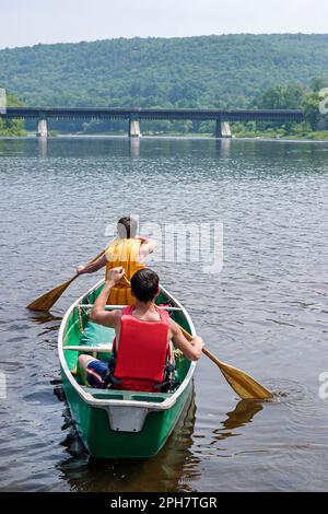 Pennsylvania Pocono Mountains Delaware River,water Lackawaxen Roebling Aqueduct Bridge,teen teens teenager teenagers boy boys friends canoeing canoe p Stock Photo