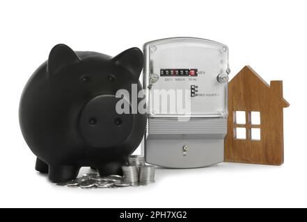 Electricity meter, house model, piggy bank and coins on white background Stock Photo