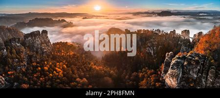 Saxon, Germany - Aerial panoramic view of the beautiful Saxon Switzerland National Park near Dresden on a foggy autumn morning with Bastei bridge, roc Stock Photo