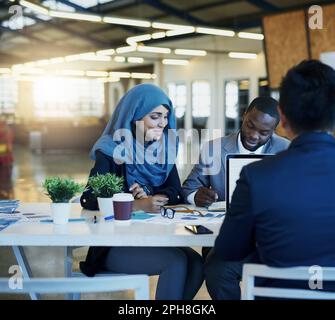 Theyre always looking for new ways to make business better. a diverse group of businesspeople working together in an office. Stock Photo