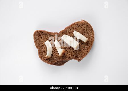 black slice of bread with lard on an isolated background, lunch Stock Photo