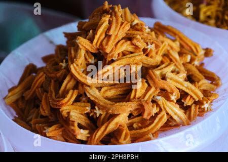 Farsan, snacks in bowls for sale in Indian Market, Traditional Indian deep fried salty dish made of gram flour and mixed with dry fruits. Stock Photo