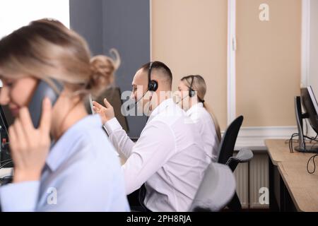Call center operators working in modern office Stock Photo