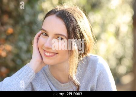 Portrait of a beautiful woman posing sitting in a park Stock Photo